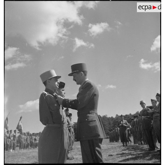 Le général de corps d'armée Leclerc décore des officiers subalternes lors de la cérémonie de passation de commandement et d'adieu à la 2e division blindée (2e DB).