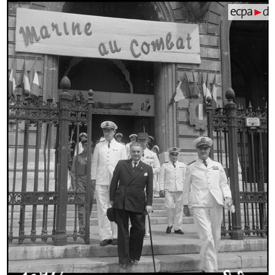 Des autorités civile et militaires sortent d'une exposition intitulée Marine au combat au palais de la Bourse.