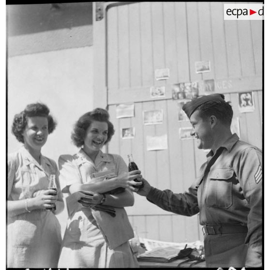 Un sergent offre des sodas (Coca-Cola) à deux personnels du corps des infirmières de l'armée américaine.