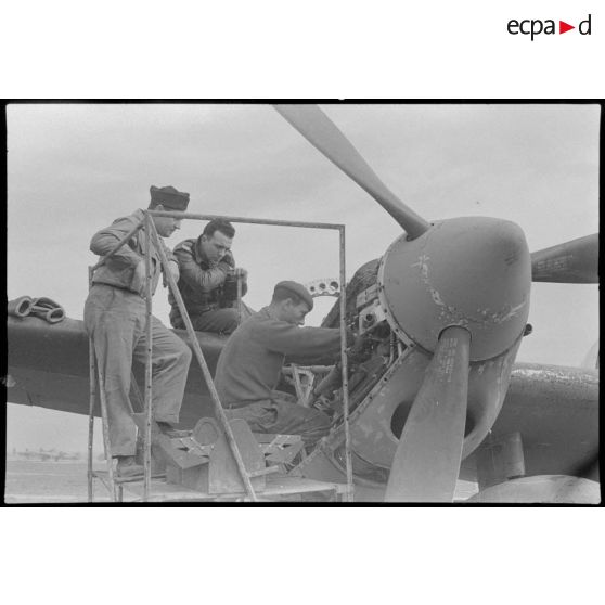 Le pilote supervise le travail de réparation des mécaniciens.