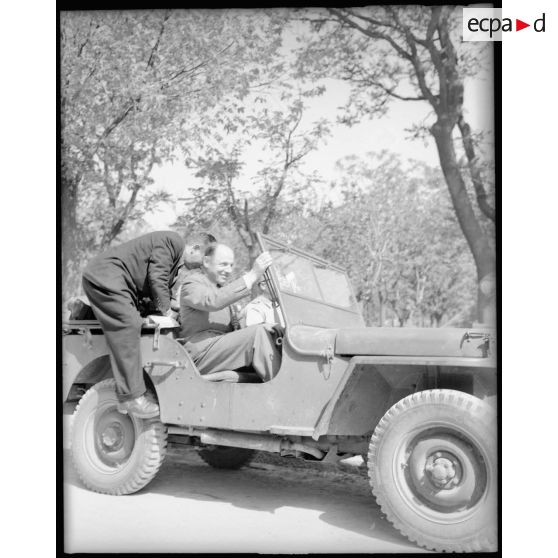 Le commissaire de l'air monte dans une "Jeep" afin de visiter les casernements des pilotes sur la base de Casablanca.