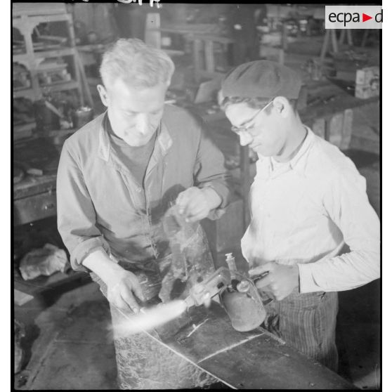 Brûlage des enduits recouvrant les pales d'hélices à l'usine Caudron en Algérie.