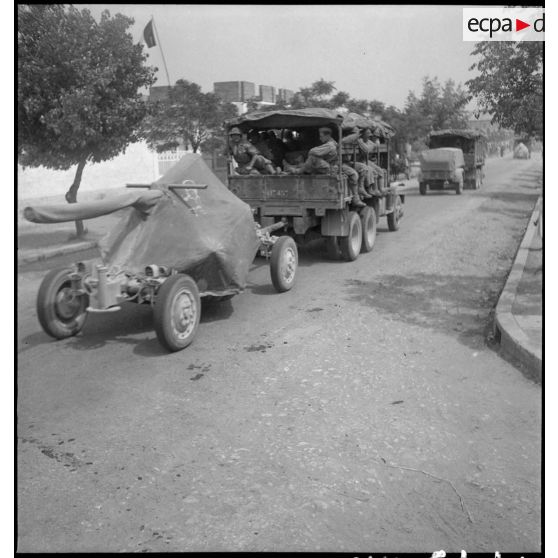 Convoi de batteries anti-aérienne et de servants sur une route de Tunisie.