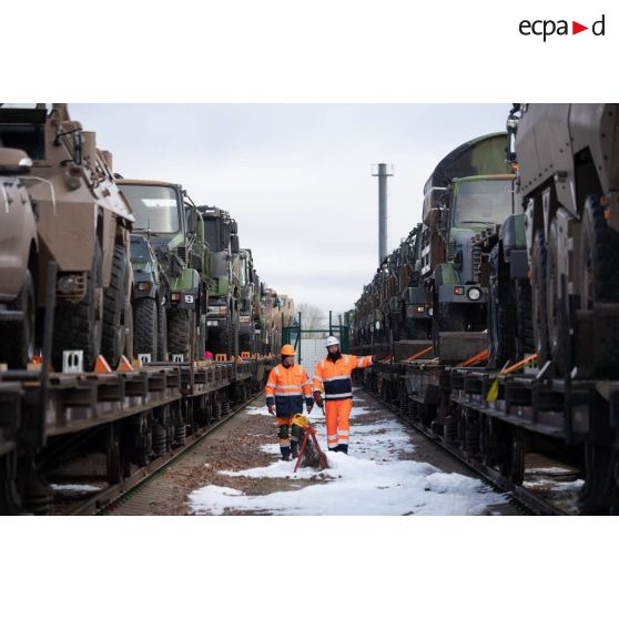 Des cheminots encadrent le déchargement des camions et des blindés depuis deux trains en gare de Tapa, en Estonie.