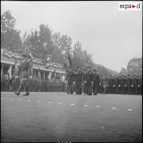 Place de la République. Défilé du drapeau et de l'Ecole polytechnique devant la tribune officielle.