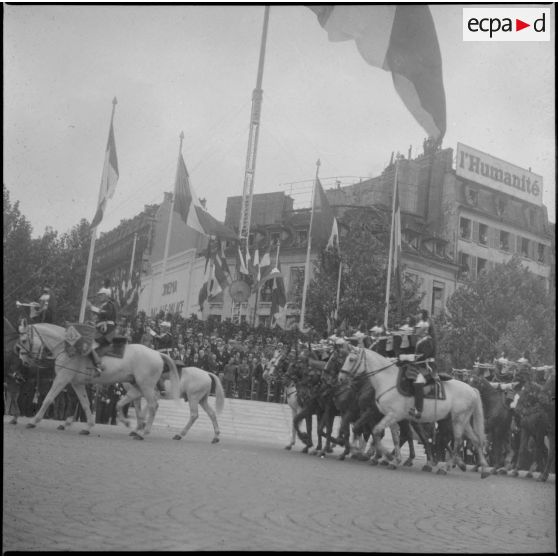 Défilé du 14 Juillet sur la place de la Bastille : les cavaliers de la fanfare de la garde républicaine de Paris devant la tribune présidentielle.