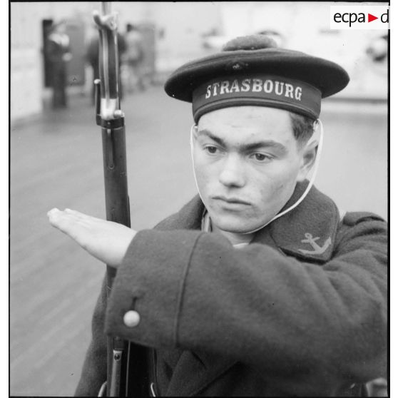 Portrait d'un marin présentant les armes à bord du cuirassé Strasbourg.