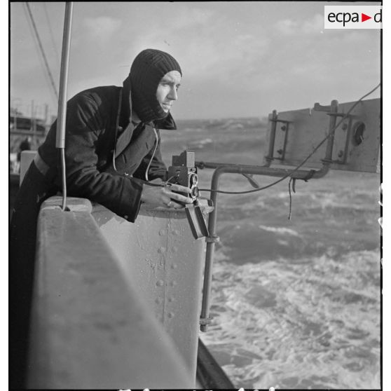 Portrait du photographe et cameraman André Costey du service cinématographique de la Marine avec un Rolleiflex.