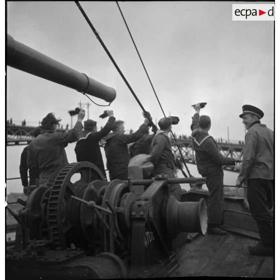 L'équipage d'un chalutier armé quittant le port de Brest salue la foule. A l'arrière plan, le pont tournant de Brest.