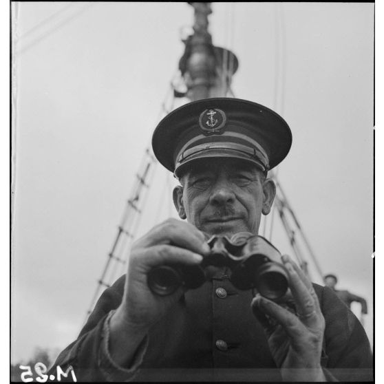 Portrait en contre-plongée du premier maître, commandant le chalutier de la marine marchande Roche noire, réquisitionné et armé par la Marine nationale.