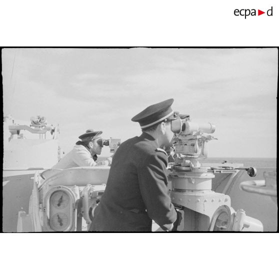 Un enseigne de vaisseau et un marin de quart assurent une veille optique des avions ou sous-marins ennemis à bord du croiseur la Marseillaise.