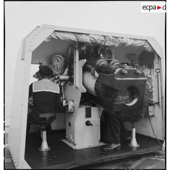 Marins à leur poste de combat sur l'un des canons simples sous masque de 100 mm modèle 1932, à bord du torpilleur léger Branlebas.