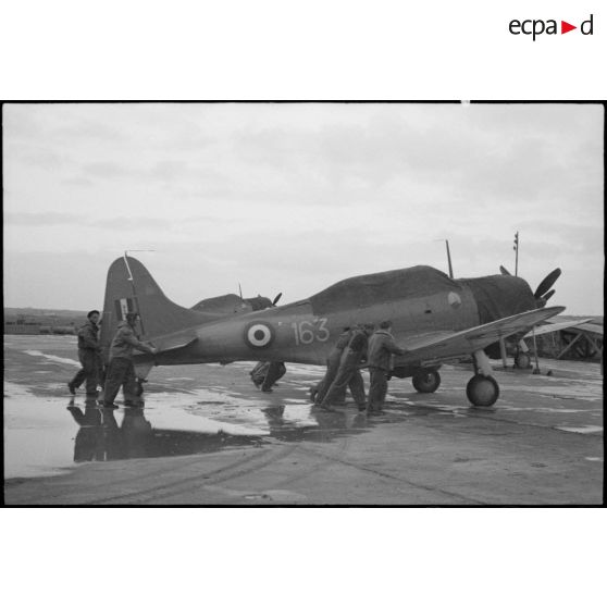 Un bombardier en piqué Douglas SBD-5 Dauntless de la flottille 4FB de l'aéronautique navale est poussé sur une piste d'envol sur la base de Cognac.