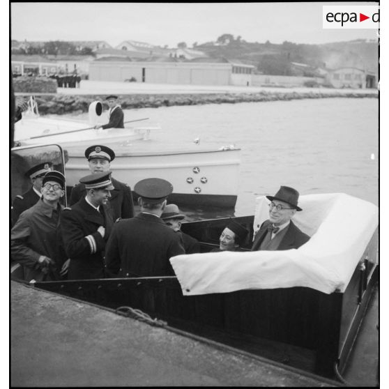 Le ministre de la Marine nationale, César Campinchi, en visite à Toulon, embarque à bord d'une vedette de la base aéronavale de Saint-Mandrier. A l'arrière-plan, la vedette du vice-amiral commandant l'escadre de Méditerranée.