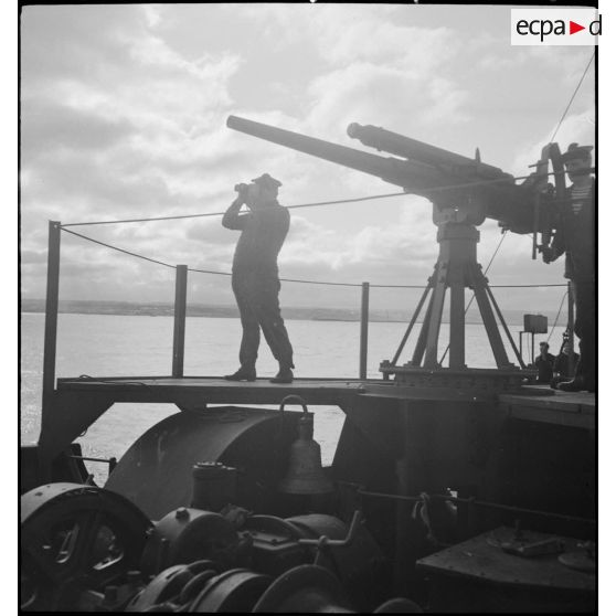 Marins à leur poste de veille au canon de 75 mm à bord d'un chalutier réquisitionné et armé par la Marine nationale.