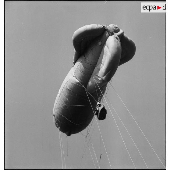 Ballon d'observation captif s'élevant dans les airs, avec ses câbles de retenue.