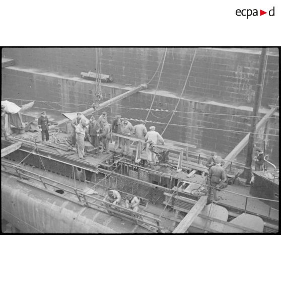 Ouvriers et marins à la maintenance sur le sous-marin mouilleur de mines Saphir, en cale sèche dans un bassin de l'arsenal de Brest.