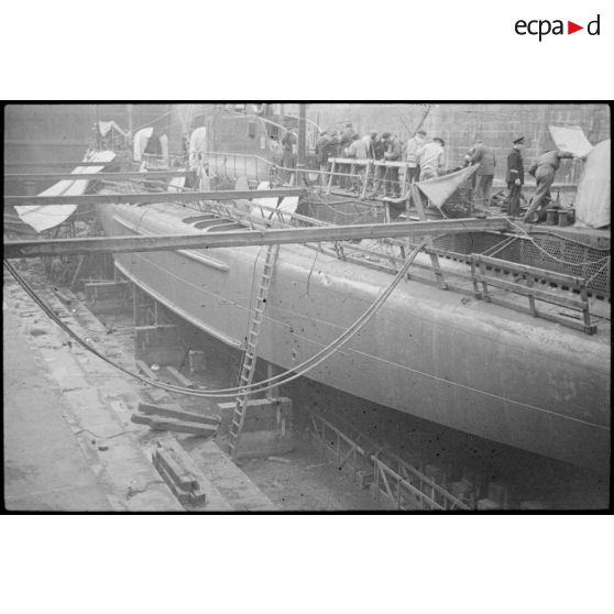 Ouvriers et marins à la maintenance sur le sous-marin mouilleur de mines Saphir, en cale sèche dans un bassin de l'arsenal de Brest.