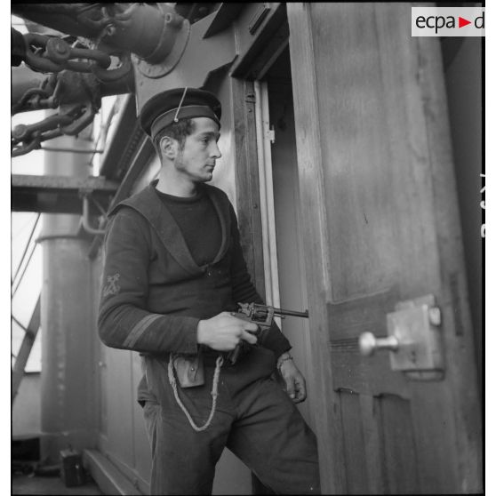 Portrait d'un quartier maître de 2e classe, membre d'équipage de l'aviso dragueur de mines Elan, pistolet au poing à bord du navire marchand allemand le Rostock.