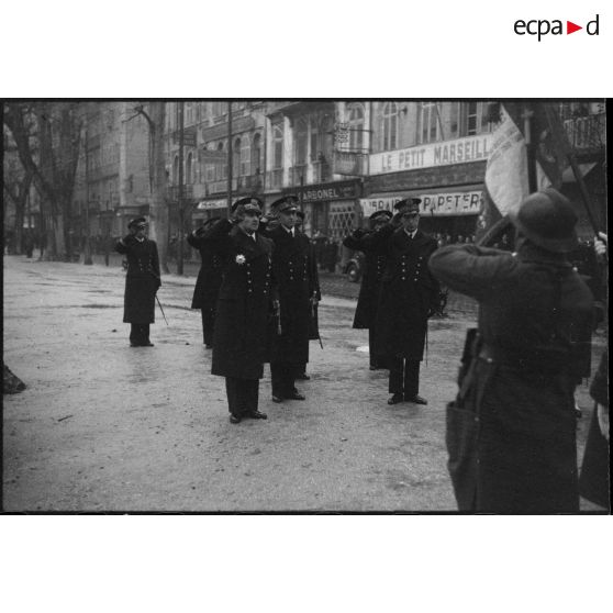 Des amiraux saluent le drapeau d'une unité de l'armée de Terre lors de l'exécution de la Marseillaise au cours d'une prise d'armes.