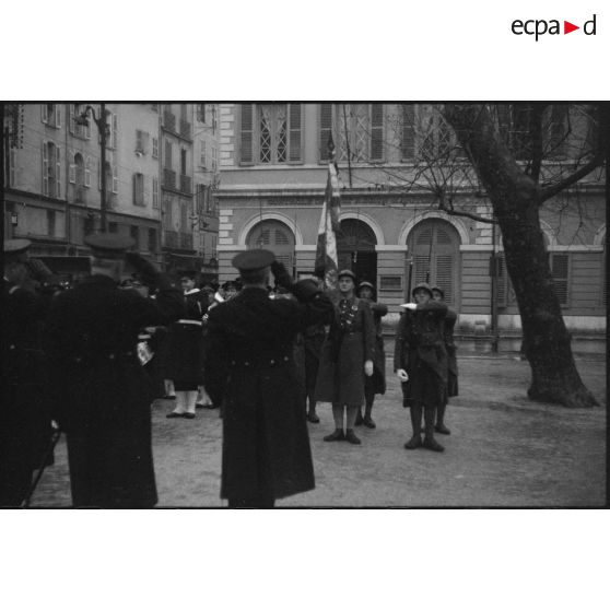 Des amiraux saluent le drapeau d'une unité de l'armée de Terre lors de l'exécution de la Marseillaise au cours d'une prise d'armes.