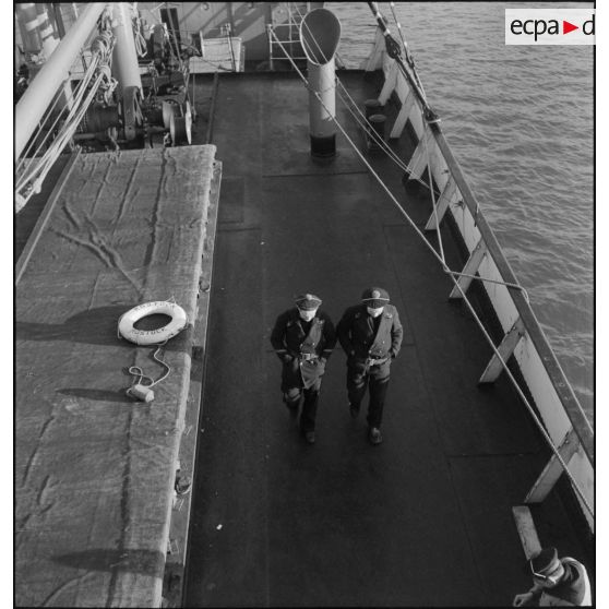 Marins français circulant sur le pont du navire marchand allemand le Rostock.