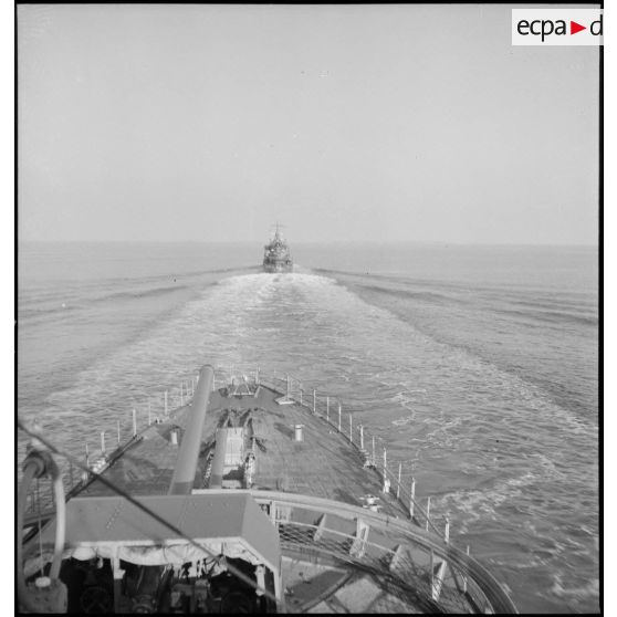 Un convoi de contre-torpilleurs d'une escadre navigue en ligne de file. Au premier plan, canons de 138 mm sur la plage avant.