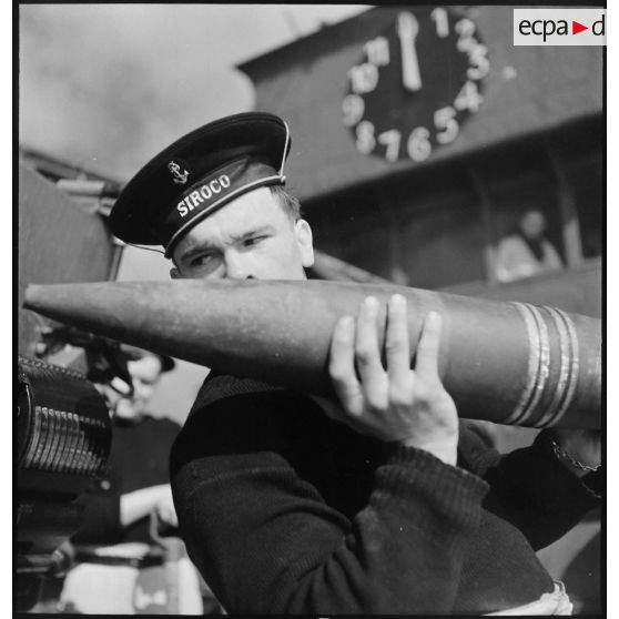 Chargement d'une pièce d'artillerie de 130 mm.