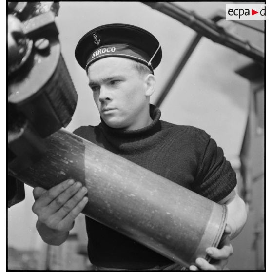 Chargement d'une pièce d'artillerie de 130 mm.