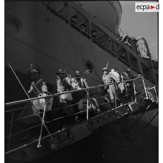 Des soldats nord-africains descendent du paquebot transport de troupes Ville d'Alger par l'échelle de coupée dans le port de Marseille.