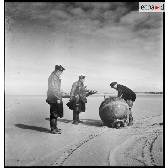 Le second maître Dudouard, chef d'équipe d'armuriers démineurs de la Marine nationale, neutralise une mine sous-marine allemande échouée sur une plage de Dunkerque.