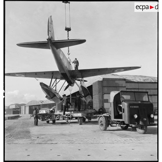 Suspendu à une grue, un hydravion Latécoère 298 de l'escadrille de torpillage T3 est mis en place sur une remorque sur la base d'aéronautique navale (BAN) de Cherbourg-Chantereyne.