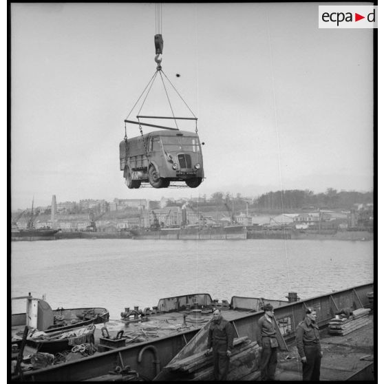 Chargement d'un camion Renault AGK à bord d'un cargo.