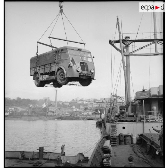 Chargement d'un camion Renault AGK à bord d'un cargo.