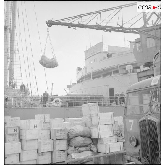 Embarquement de sacs de vivres destinés au CEFS (Corps expéditionnaire français en Scandinavie) à bord d'un des cargos.