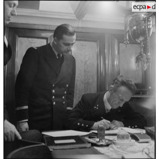 Le commandant du cargo danois Anna saisi, renseigne et signe les documents du bord et ceux remis par un officier de la police de la navigation.