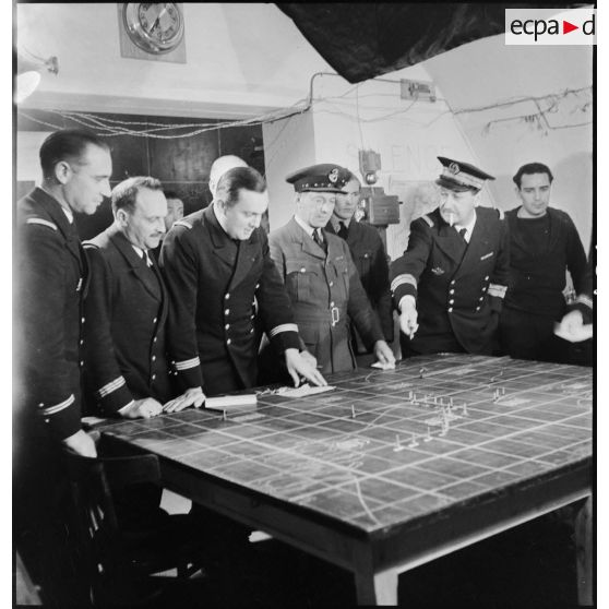 Des officiers de la Marine nationale et de la RAF (Royal Air Force) sont rassemblés devant une carte dans la salle des opérations du poste de commandement à Dunkerque.