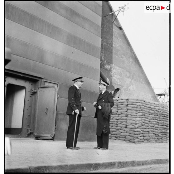 L'amiral Jean-Marie Abrial, commandant les forces navales du Nord et la place de Dunkerque s'entretient avec un officier de marine devant le poste de commandement de l'amiral.