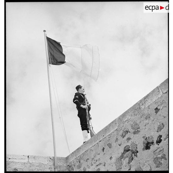 Une sentinelle d'une unité de défense côtière, canonnier marin algérien, dit Baharia, est en faction devant le mât des couleurs au fort de Mers-el-Kébir.