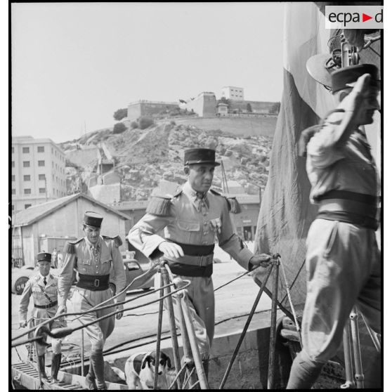 Des légionnaires du 1er régiment étranger d'infanterie (REI) montent à bord du contre-torpilleur L'Indomptable, amarré dans le port d'Oran.