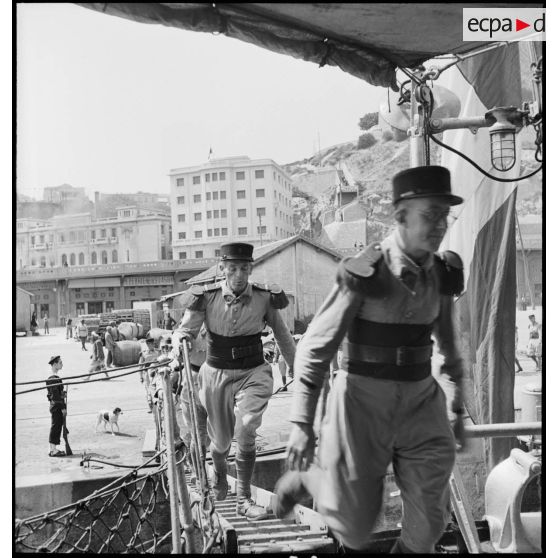 Des légionnaires du 1er régiment étranger d'infanterie (REI) montent à bord du contre-torpilleur L'Indomptable, amarré dans le port d'Oran.