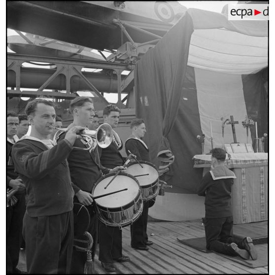 Tambours et clairons à bord du cuirassé Dunkerque pendant la célébration d'un office sur le navire.