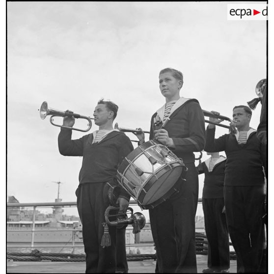 Tambours et clairons à bord du cuirassé Dunkerque pendant la célébration d'un office sur le navire.