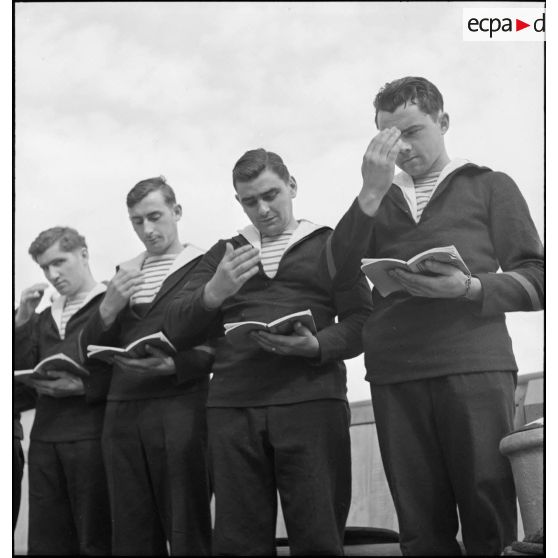 Des matelots du cuirassé Dunkerque assistent à une messe célébrée à bord du navire.