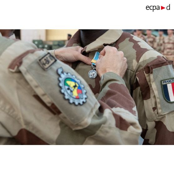 Le colonel Grégoire Chéreau du 4e régiment du matériel (RMAT) décore un soldat de la médaille d'Outre-mer avec agrafe Sahel à Niamey, au Niger.