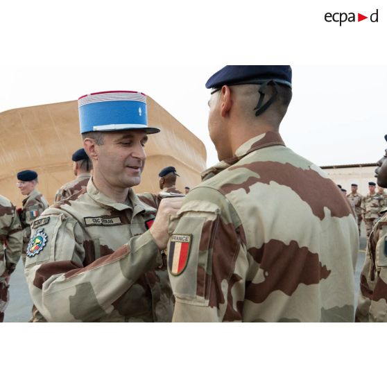 Le colonel Grégoire Chéreau du 4e régiment du matériel (RMAT) décore un soldat de la médaille d'Outre-mer avec agrafe Sahel à Niamey, au Niger.