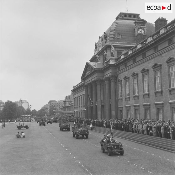 Défilé motorisé devant l'Ecole militaire. Passage du drapeau et sa garde du 35e régiment d’artillerie parachutiste (35e RAP), à bord d'une Jeep de type Hotchkiss M-201, suivi de camionnettes Simca-Marmon, lors de la cérémonie du 14 juillet 1977.