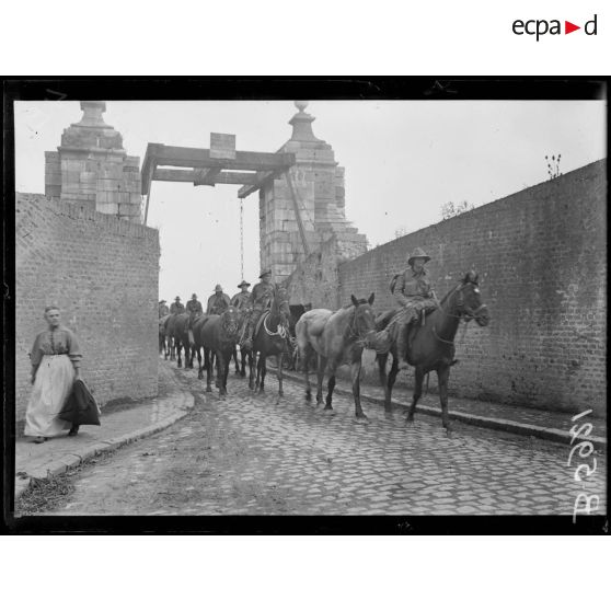 Bergues (Nord). Un détachement de cavaliers australiens traversant le pont levis des anciennes fortifications de la ville. [légende d'origine]