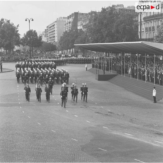 Défilé à pied des drapeaux et leur garde de l'école spéciale militaire (ESM) et de l'école militaire interarmées (EMIA) de Saint-Cyr-Coëtquidan, et passage devant la tribune présidentielle lors de la cérémonie militaire du 14 juillet 1974 sur la place de la Bastille.