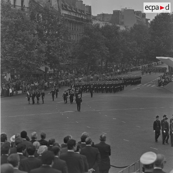 Défilé à pied. Passage des drapeaux et leur garde des écoles du service de santé (ESSA) de Lyon et Bordeaux devant les tribunes lors de la cérémonie du 14 juillet 1979 sur la place de la Bastille.